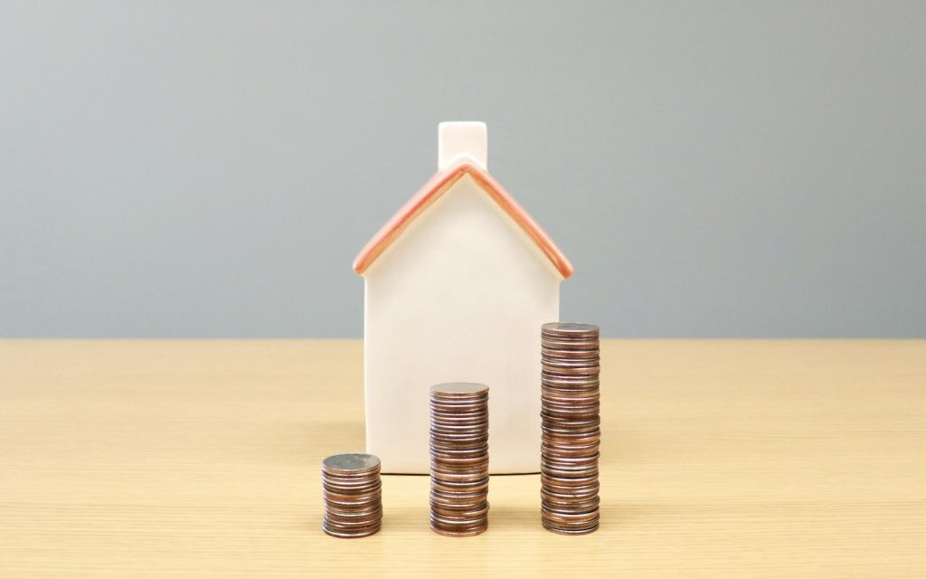 Model house beside stacks of coins